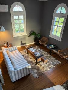 a living room with a couch and a table and two windows at La Olivia Hotel Boutique & Spa in La Falda