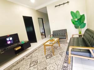 a living room with a couch and a tv at D'Cozy Homestay in Seri Manjung