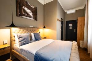 sypialnia z dużym łóżkiem z niebieskimi poduszkami w obiekcie Vayalen Boutique Hotel w Wiedniu