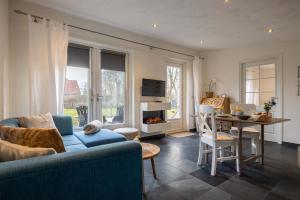 a living room with a couch and a table and a dining room at NEW Hello Zeeland - Cozy Country Cottage in Wissenkerke