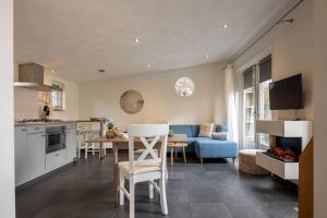 a kitchen and living room with a table and a couch at NEW Hello Zeeland - Cozy Country Cottage in Wissenkerke