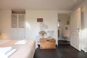 a bedroom with two beds and a toilet in it at NEW Hello Zeeland - Cozy Country Cottage in Wissenkerke