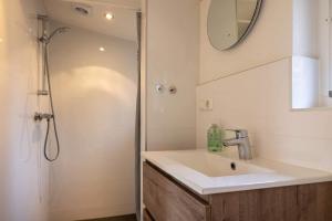 a bathroom with a sink and a shower at NEW Hello Zeeland - Cozy Country Cottage in Wissenkerke +20 photos