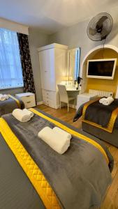 a hotel room with two beds and a desk at Piccolino Hyde Park Hotel in London