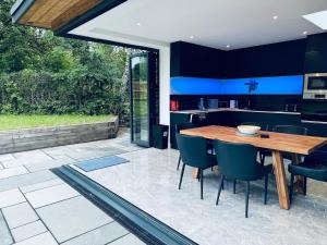 a kitchen and dining room with a wooden table and chairs at Knatchbull Cottage in Downhead