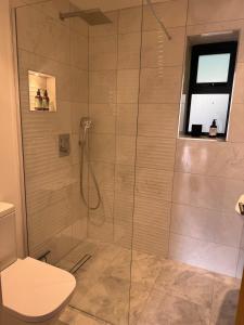 a shower with a glass door in a bathroom at Knatchbull Cottage in Downhead +44 photos