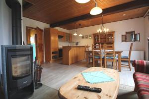 a living room with a wooden table and a kitchen at Gundi's Ferienhaus in Dorum-Neufeld