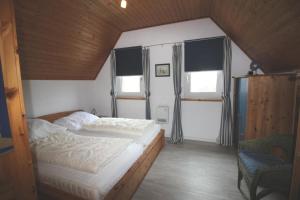 a bedroom with two beds and two windows at Gundi's Ferienhaus in Dorum-Neufeld