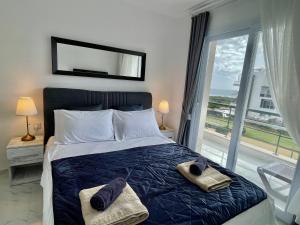 a bedroom with a bed and a large window at Blue Retreat Suites by the Sea in Vokolidha