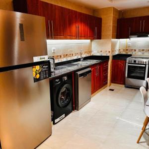 a kitchen with a stainless steel refrigerator and a dishwasher at Best place to stay by the sea in Ajman 