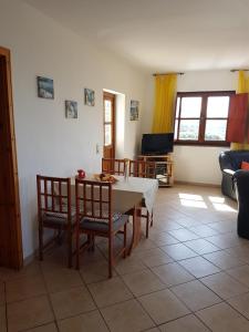 a living room with a table and chairs and a tv at Cortijo de la luz App Sol in Almuñécar
