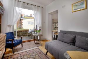 a living room with a couch and a window at Chantry Cottage in Chard