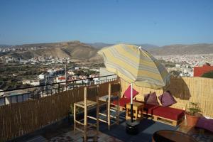 eine Terrasse mit Stühlen und einem Sonnenschirm auf einem Balkon in der Unterkunft Epicswellhouse in Agadir