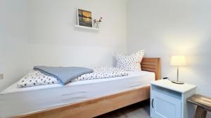 Un dormitorio con una cama con sábanas y almohadas blancas. en Fewo Kandis und Wölkchen, en Norden