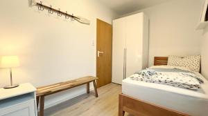 1 dormitorio con cama y banco. en Fewo Kandis und Wölkchen, en Norden