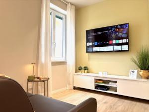 een woonkamer met een flatscreen-tv aan de muur bij Residenza Betteloni in Bardolino