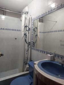 a bathroom with a blue toilet and a tub at Mandalas Cusco in Cusco