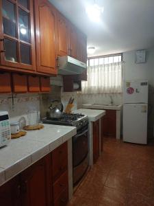 a kitchen with wooden cabinets and a stove top oven at Mandalas Cusco in Cusco +21 photos