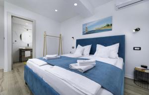 a blue and white bed with two towels on it at Sea View Casa Oliva Island Krk in Dobrinj +11 photos