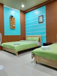 a room with two beds and a blue wall at Q HOME Đà Lạt in Da Lat