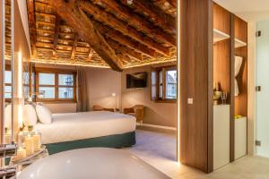a bedroom with a bed and a tub in a room at Axel Hotel Valencia - Adults Only in Valencia