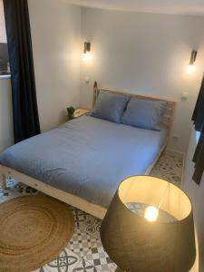 a bedroom with a bed with a lamp and a table at Centre-Ville Parking Gratuit Proche Aéroport in Beauvais