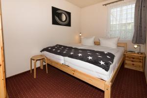 a bedroom with a bed with a black and white comforter at Ferienhaus Saturn im Sternenpark in Lochow