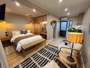 a bedroom with a bed and a living room at Knysna Elephant Park Lodge in Plettenberg Bay