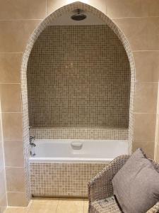a bathroom with a bath tub with an arched niche at Spacious, cosy 6 bedroom house which sleeps 11 in Banchory