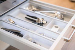 a white drawer with utensils in a kitchen at Gästehaus "Alte Bücherei" Satrup in Mittelangeln