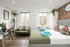 a bedroom with a large bed and a living room at Green Park Studios in London