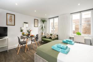 a bedroom with a bed and a living room at Green Park Studios in London