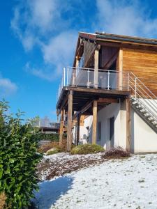 a house on the beach with a deck at chalets les biches in Gérardmer
