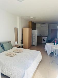 une chambre avec un grand lit blanc et une cuisine dans l'établissement Marielenas, à Larnaka