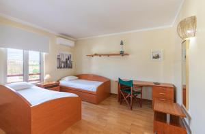 Un dormitorio con dos camas y un escritorio y una mesa. en Apartamento dentro da Marina de Vilamoura, en Vilamoura