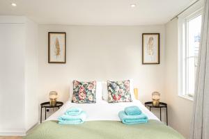 a bedroom with a bed with blue towels on it at Green Park Studios in London +19 photos