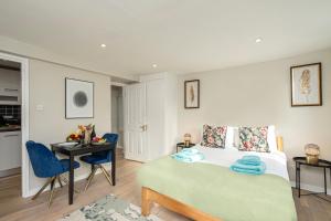 a bedroom with a bed and a table and a desk at Green Park Studios in London