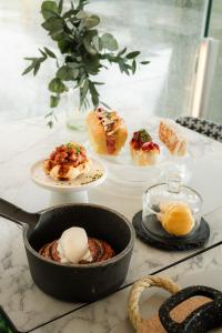 a table topped with plates of pastries and desserts at Hospes Puerta de Alcalá, a Member of Design Hotels in Madrid