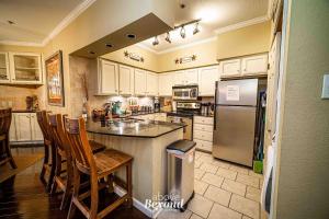 a kitchen with white cabinets and a counter with chairs at Sunset & Lake View on Island Retreat in Lago Vista