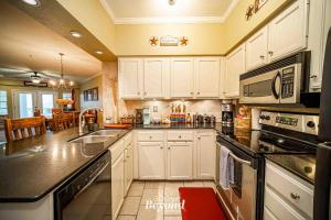a kitchen with white cabinets and black counter tops at Sunset & Lake View on Island Retreat in Lago Vista +57 photos