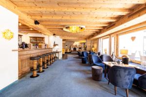 restauracja z drewnianymi sufitami, stołami i krzesłami w obiekcie Beauty & Wellness Hotel Tirolerhof w mieście Nauders