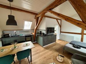 eine Küche und ein Wohnzimmer mit einem Tisch im Zimmer in der Unterkunft Ferienwohnungen Brenner einchecken und wohlfühlen in Langenbernsdorf
