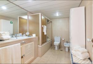 Un baño con inodoro, lavabo y ducha. en Apartamento dentro da Marina de Vilamoura, en Vilamoura 21 fotos más