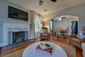 Una sala de estar con chimenea y un televisor encima. en Bama Bungalow, en Tuscaloosa