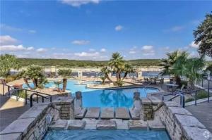 una piscina en el resort con palmeras en Meet Me At The Lake, en Lago Vista