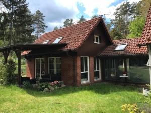 a house with a red roof at Waldoase 2 in Rheinsberg