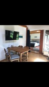 a living room with a wooden table and a bedroom at Waldoase 2 in Rheinsberg