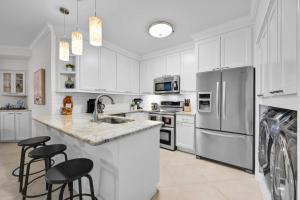 a kitchen with white cabinets and stainless steel appliances at Island Summer Sunrises Spa Eats Last Minute Deals! in Lago Vista