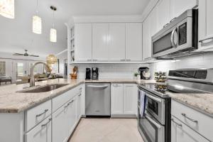 a kitchen with white cabinets and a sink at Island Summer Sunrises Spa Eats Last Minute Deals! in Lago Vista +48 photos