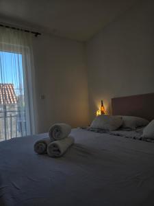 a bedroom with two towels on a bed with a window at Apartman Lucija in Jezera